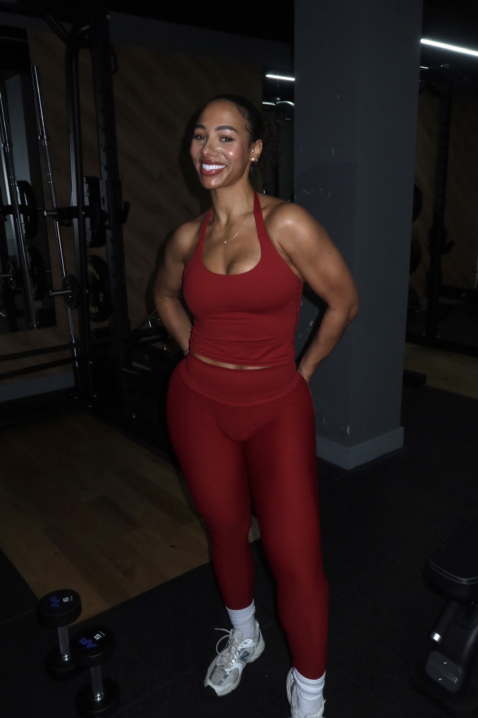 Christina Okenla wearing a red workout set in the gym
